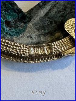 Chinese coin pendant, set in a gold-toned frame. 10K