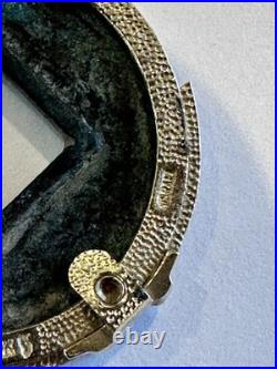 Chinese coin pendant, set in a gold-toned frame. 10K