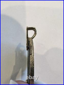 Chinese coin pendant, set in a gold-toned frame. 10K